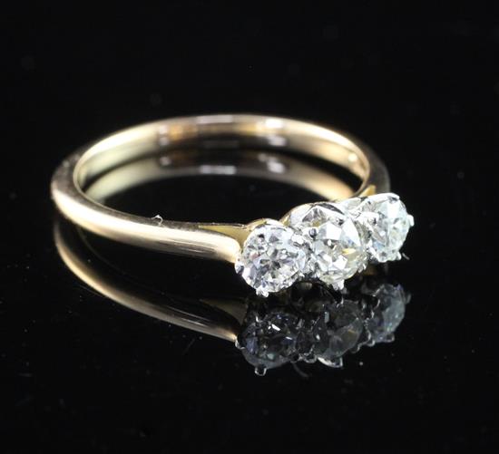 An 18ct gold and platinum three stone diamond ring, size M.